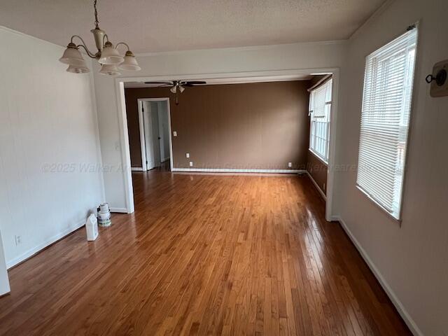 314 Crescent Cir, Jasper, AL 35503 - spare room featuring plenty of natural light, ceiling fan with notable chandelier, baseboards, and hardwood / wood-style floors