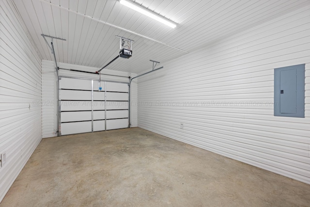 garage featuring metal wall, a garage door opener, and electric panel