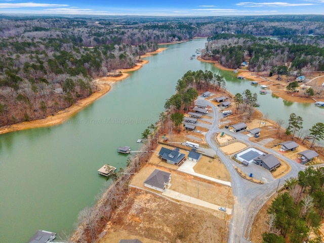 bird's eye view featuring a wooded view and a water view
