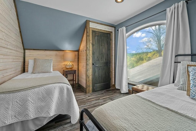 bedroom with lofted ceiling, wooden walls, wood finished floors, and recessed lighting