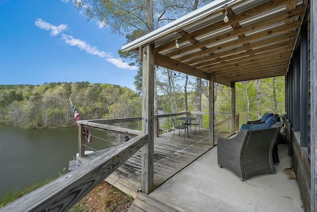 view of dock with a forest view and a deck with water view