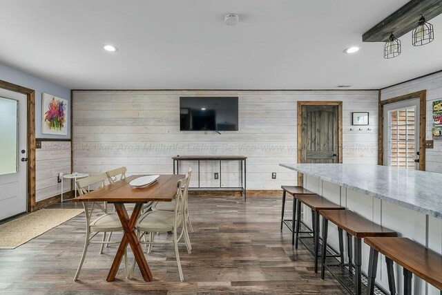 dining area with wood walls, dark wood-style flooring, and recessed lighting
