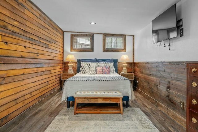 bedroom featuring wood finished floors and wooden walls