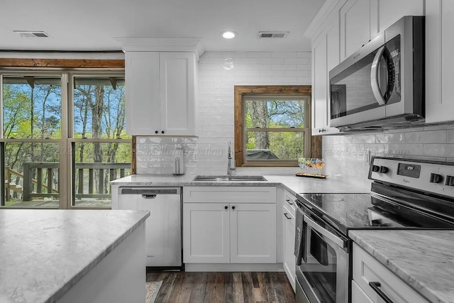 kitchen with decorative backsplash, stainless steel appliances, visible vents, and a sink