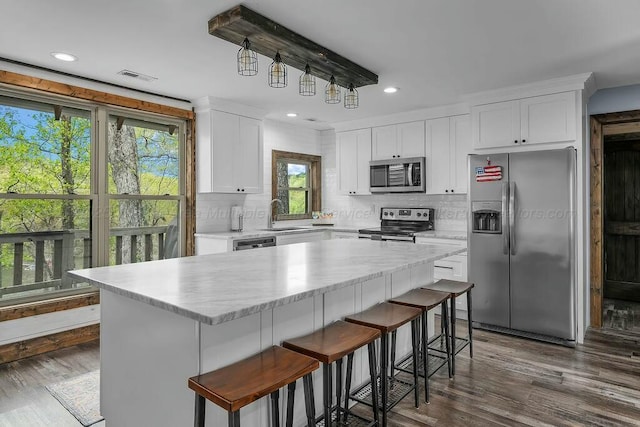 kitchen with light countertops, tasteful backsplash, visible vents, and stainless steel appliances