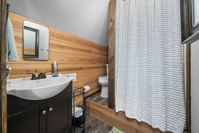 bathroom featuring wood finished floors, vanity, curtained shower, and toilet