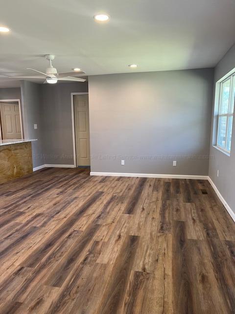 empty room with baseboards, ceiling fan, recessed lighting, and dark wood-type flooring