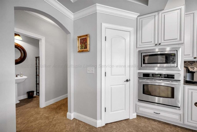 187 S Pointe Dr, Arley, AL 35541 - kitchen with stainless steel appliances, crown molding, tile patterned floors, arched walkways, and baseboards