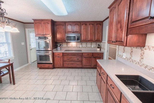 kitchen featuring sink, hanging light fixtures, stainless steel appliances, tasteful backsplash, and crown molding