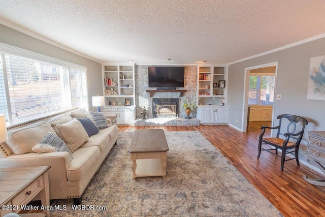 living room featuring a fireplace, hardwood / wood-style floors, a textured ceiling, and plenty of natural light