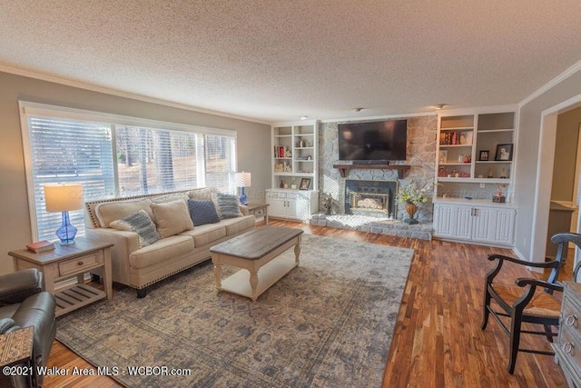 living room featuring a fireplace, dark hardwood / wood-style flooring, a textured ceiling, and crown molding