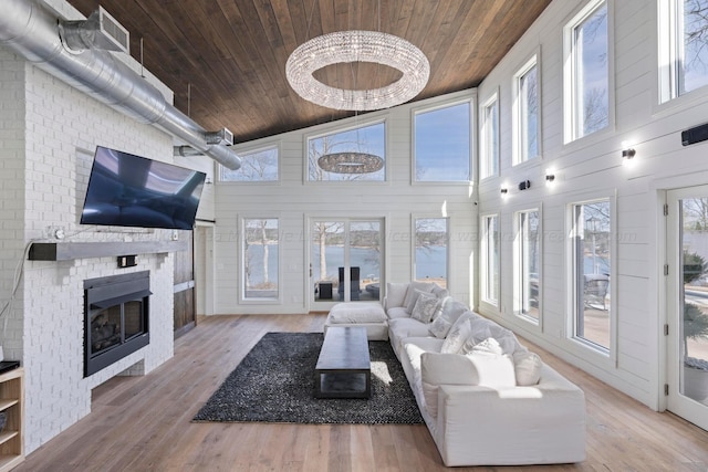 living room with a brick fireplace, wood ceiling, and wood finished floors