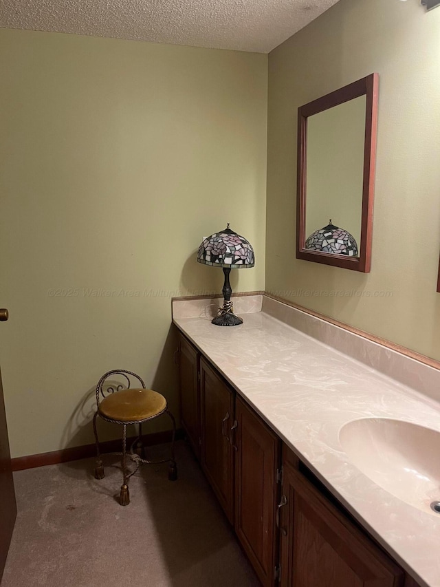 bathroom featuring vanity, baseboards, and a textured ceiling