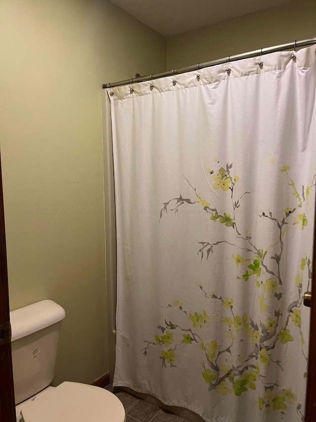 bathroom with toilet and curtained shower