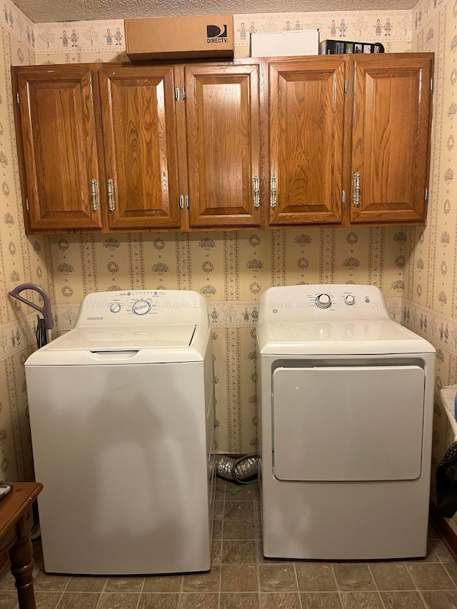washroom featuring wallpapered walls, cabinet space, and washing machine and clothes dryer