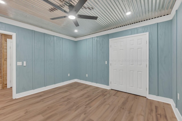 unfurnished bedroom featuring a closet, a ceiling fan, wood ceiling, wood finished floors, and baseboards