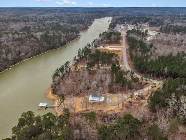 drone / aerial view featuring a forest view and a water view