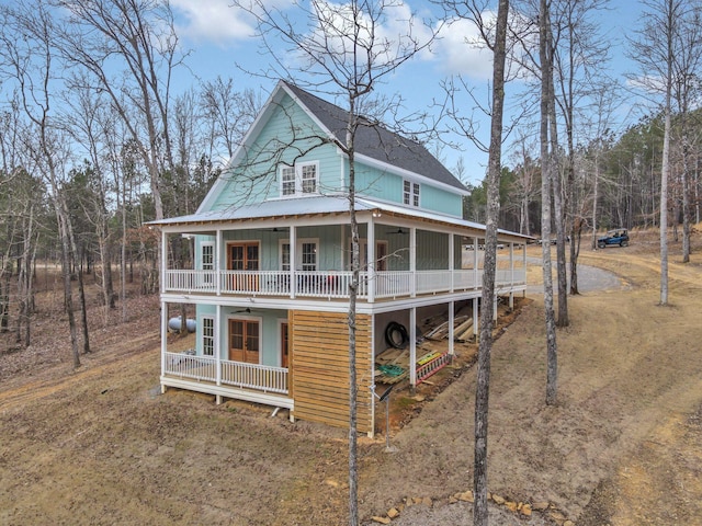 view of front facade featuring covered porch, dirt driveway, and ceiling fan