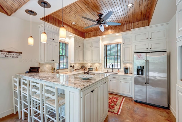 kitchen with decorative backsplash, a sink, stainless steel fridge, and wooden ceiling