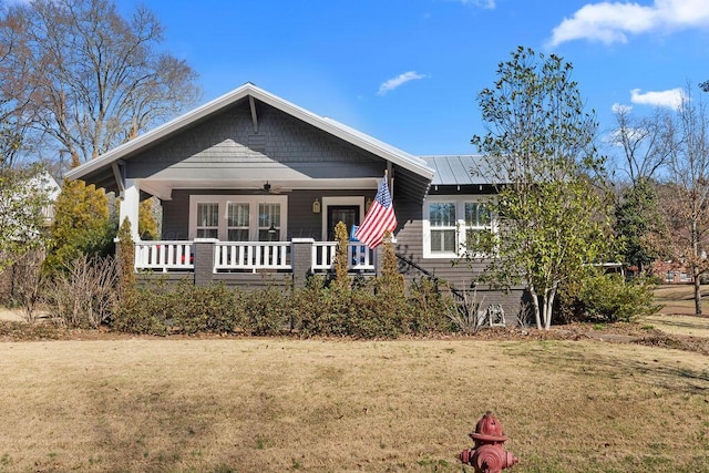 view of front of property with ceiling fan, a front yard, a porch, and metal roof