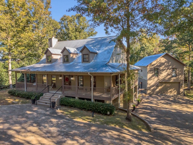 farmhouse inspired home with a garage and a porch