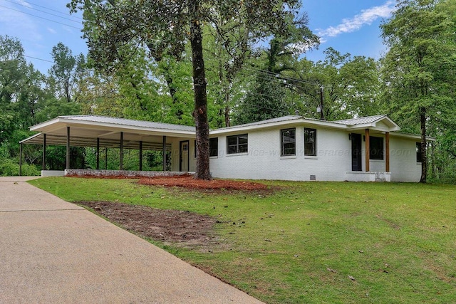 ranch-style home with concrete driveway, a carport, a front yard, metal roof, and brick siding