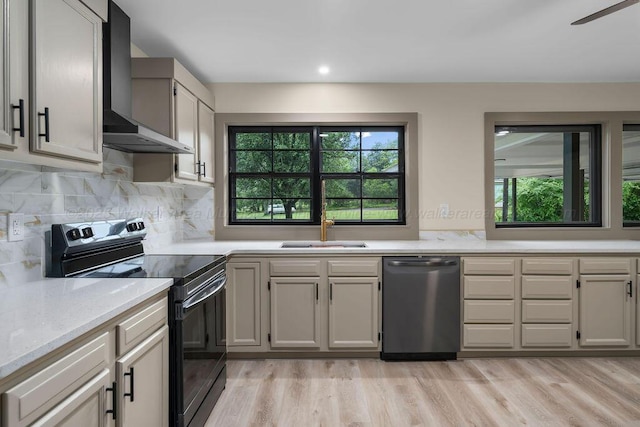 kitchen with black electric range oven, stainless steel dishwasher, wall chimney range hood, a sink, and a healthy amount of sunlight