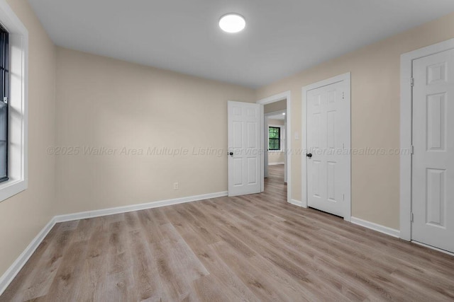 spare room with wood finished floors and baseboards