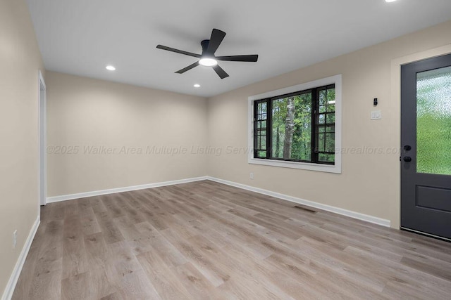 spare room with baseboards, wood finished floors, visible vents, and a wealth of natural light