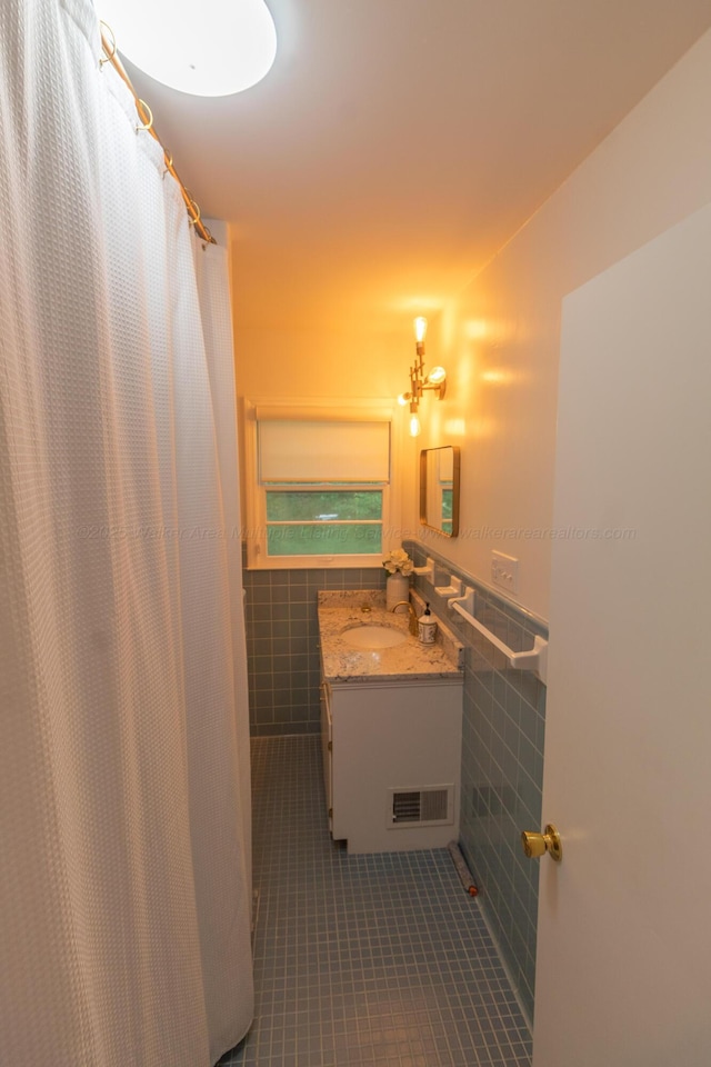 3111 18th Ave, Haleyville, AL 35565 - full bath with tile walls, tile patterned floors, vanity, and a wainscoted wall