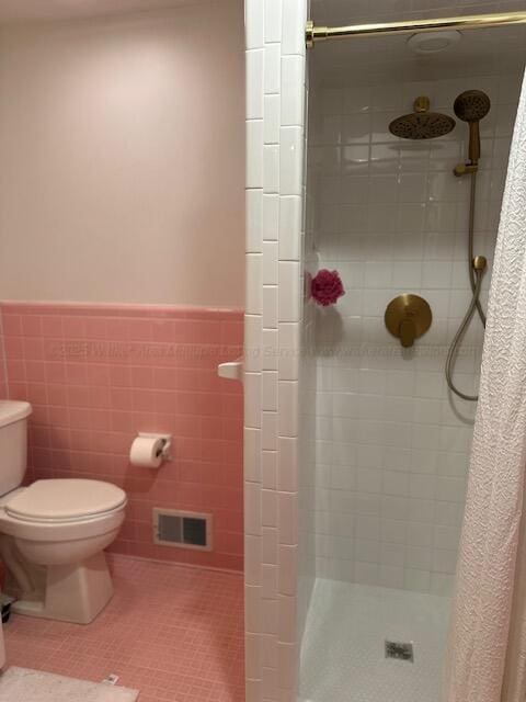 3111 18th Ave, Haleyville, AL 35565 - bathroom featuring a stall shower, a wainscoted wall, tile patterned floors, and tile walls