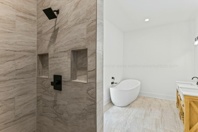 bathroom featuring a soaking tub, vanity, baseboards, and a tile shower