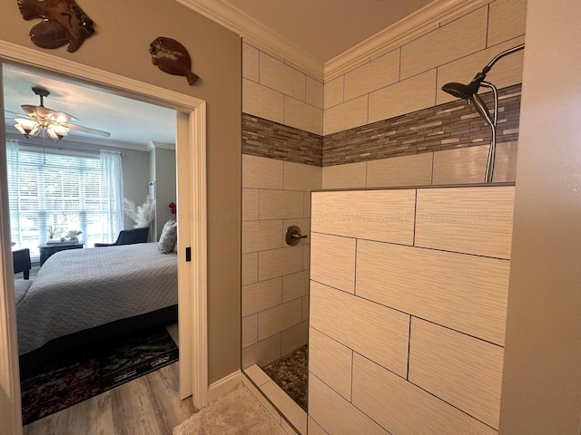 ensuite bathroom featuring crown molding, walk in shower, wood finished floors, and a ceiling fan