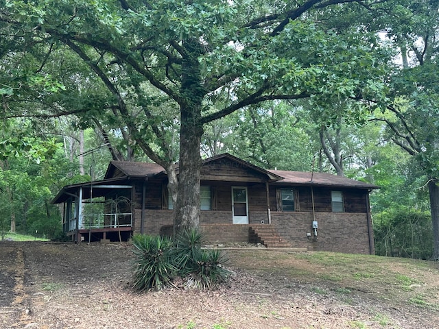 47 Hyche Rd, Cordova, AL 35550 - ranch-style house featuring a porch, brick siding, and a view of trees