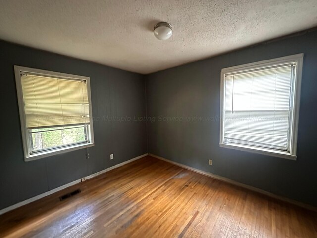 47 Hyche Rd, Cordova, AL 35550 - empty room with hardwood / wood-style flooring, baseboards, and a textured ceiling