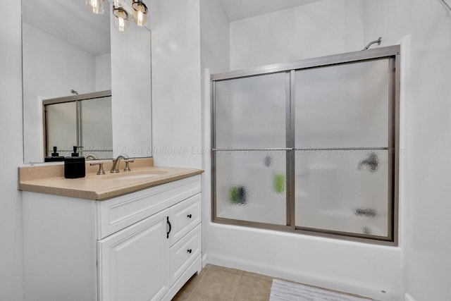 full bathroom featuring tile patterned floors, vanity, and bath / shower combo with glass door