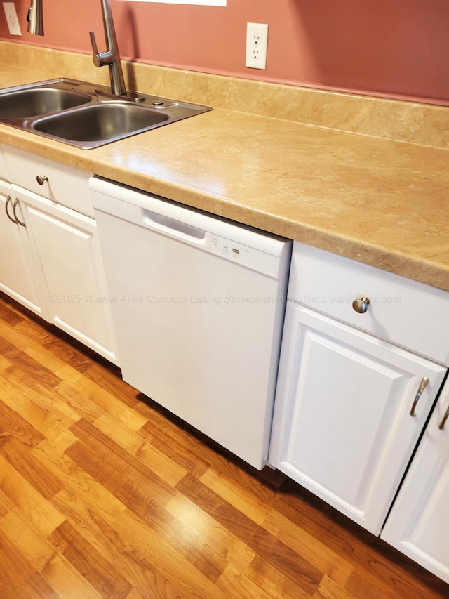 kitchen with a sink, white cabinetry, white dishwasher, and light wood finished floors