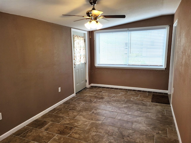 interior space with baseboards, vaulted ceiling, and a ceiling fan