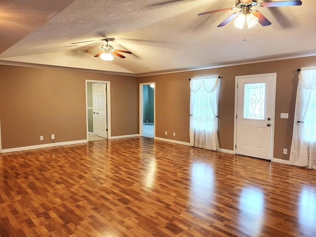 interior space with a textured ceiling, lofted ceiling, ceiling fan, and wood finished floors