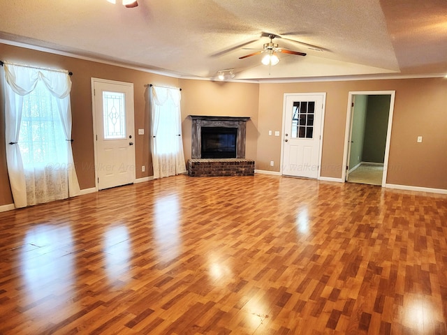 unfurnished living room featuring a fireplace, wood finished floors, a textured ceiling, baseboards, and ceiling fan