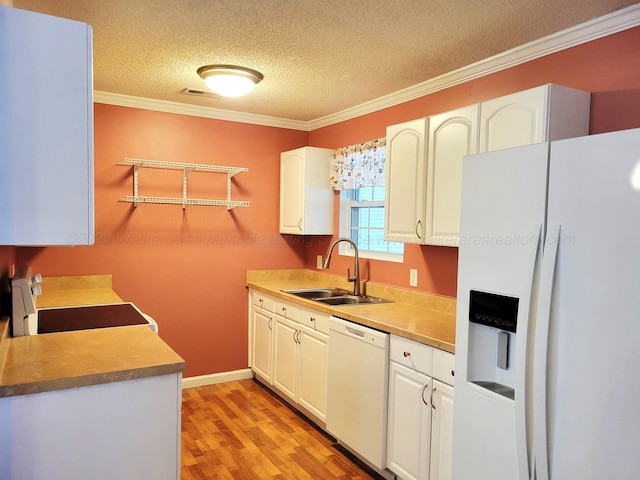 kitchen with a sink, white cabinetry, white appliances, light wood-style floors, and ornamental molding
