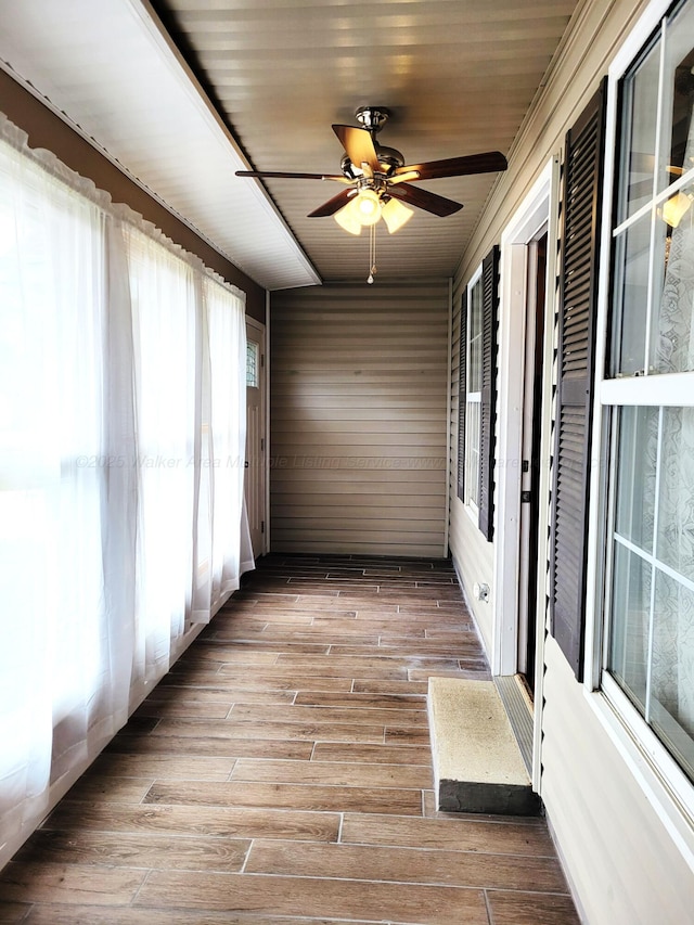 unfurnished sunroom featuring a ceiling fan