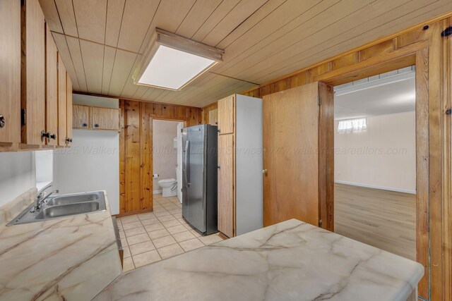 60 County Road 304, Cullman, AL 35057 - kitchen featuring freestanding refrigerator, wooden walls, wood ceiling, and light tile patterned flooring