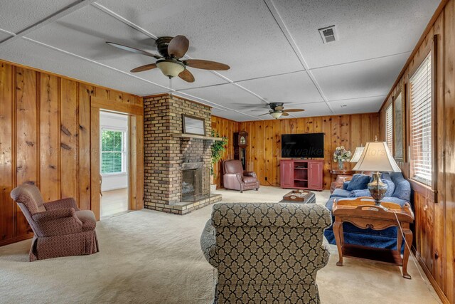 60 County Road 304, Cullman, AL 35057 - living room with wooden walls, a ceiling fan, light colored carpet, and a brick fireplace