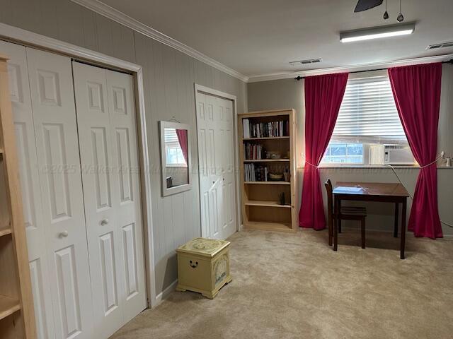 interior space featuring carpet flooring, visible vents, cooling unit, and crown molding