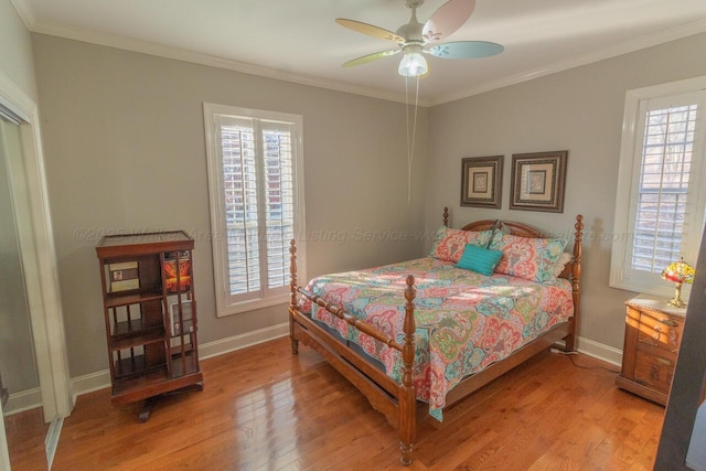 bedroom featuring crown molding, baseboards, multiple windows, and light wood-type flooring