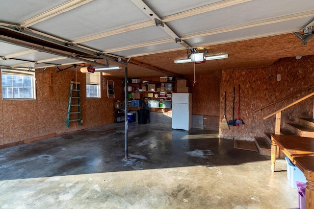 garage featuring a garage door opener and freestanding refrigerator