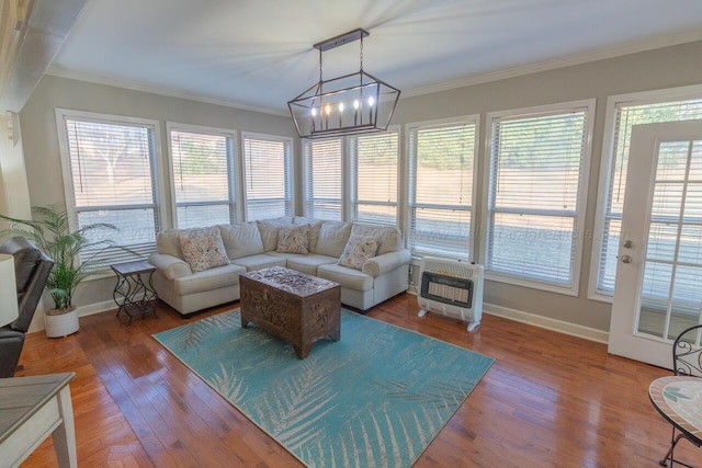 sunroom / solarium with heating unit and a chandelier