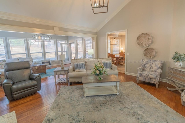 living area featuring a healthy amount of sunlight, wood finished floors, and an inviting chandelier