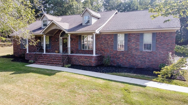 cape cod-style house with a front yard, a porch, brick siding, and roof with shingles